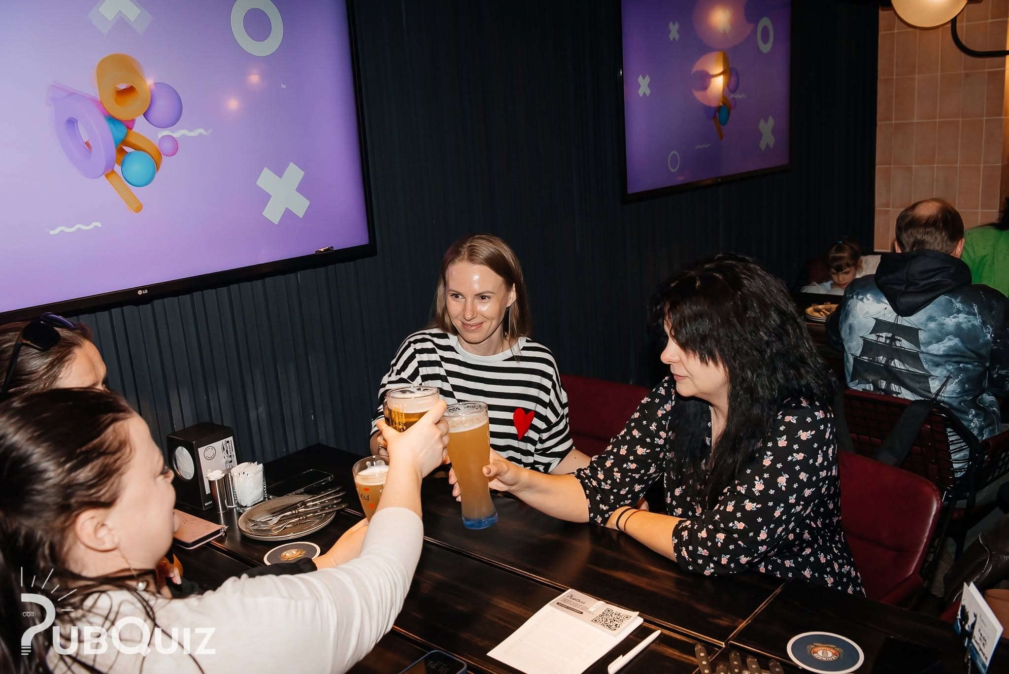 Команда цокається келихами за грою PubQuiz